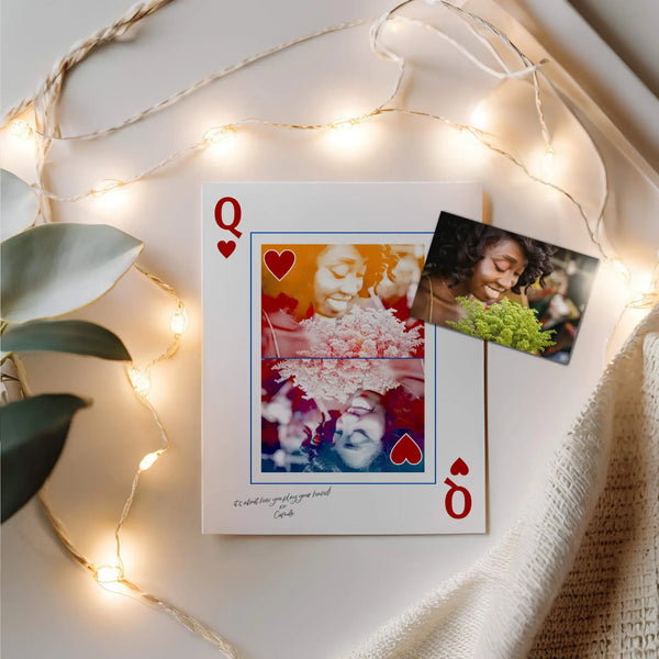 Queen of Hearts Portrait Print with a photo of a woman on top. Print is surrounded string lights and next to cream coloured linen.