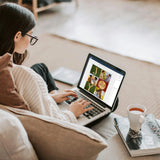 woman editing photo collage from laptop next to cup of tea