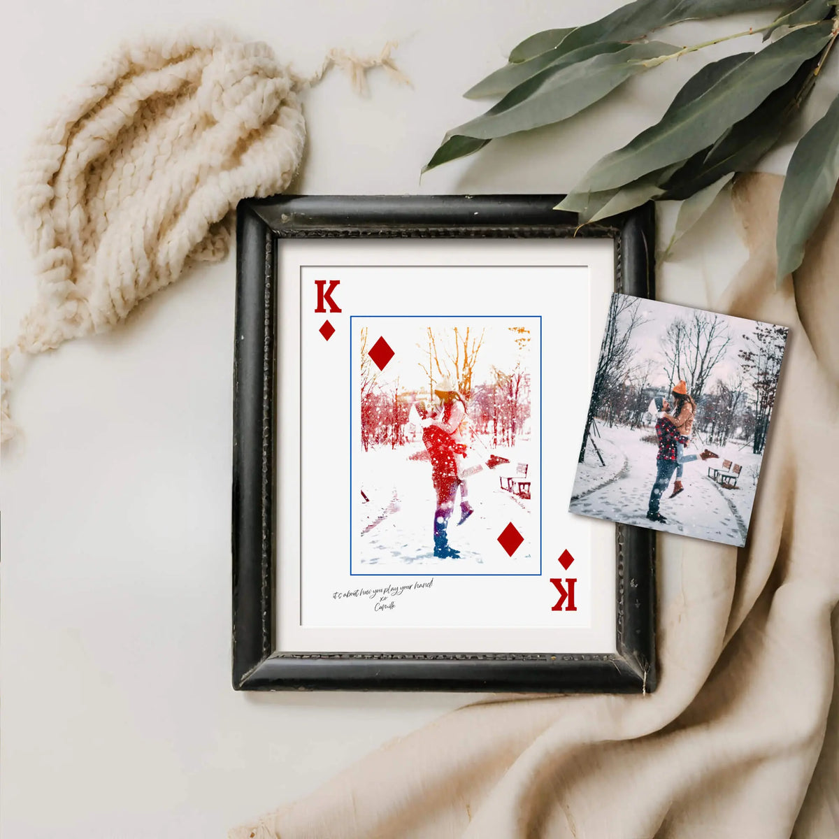 King of Diamonds Style Portrait in distressed black frame laying next to branch and beige knitted wears with a photo on top.