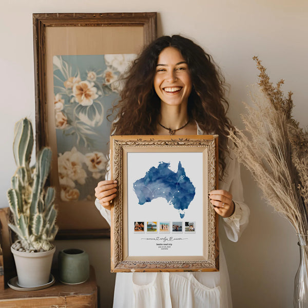 Woman holding print of blue Australia map collage in wooden frame