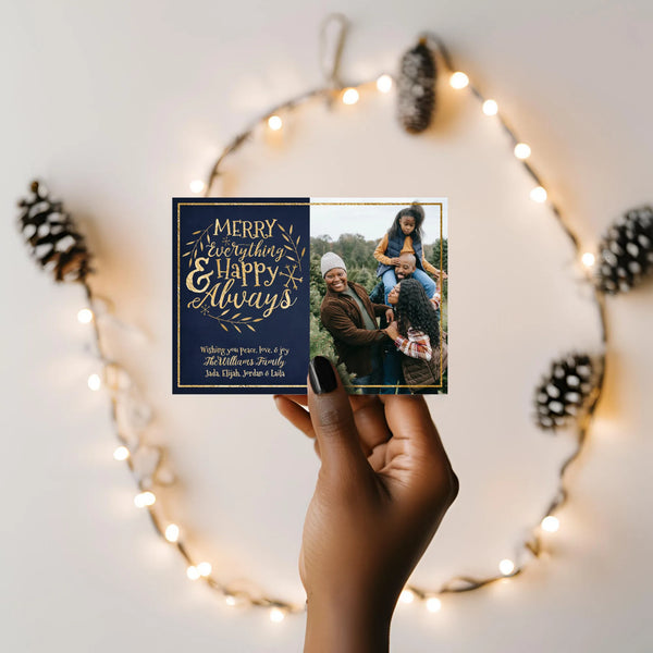 Hand holding holiday photo card with string lights in background