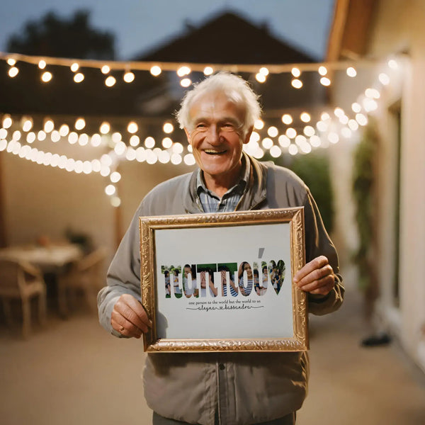 Older man holding framed pappou photo collage outside with string lights in the background.