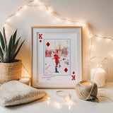 Diamonds Style Portrait in large, thin, wooden frame standing next to potted plant and candle and surrounded by string lights.