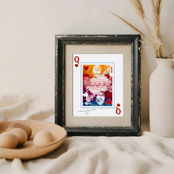 queen of hearts portrait in distressed black frame next to cream coloured vase