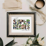 Super Heroes Photo Collage in a distressed black frame lying next to flowers, a cup, and beige coloured linen.